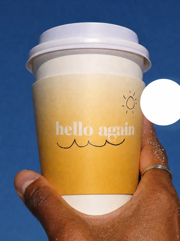 A rejected take: a hand holds the cup up to the sky, its sleeve running almost to the base